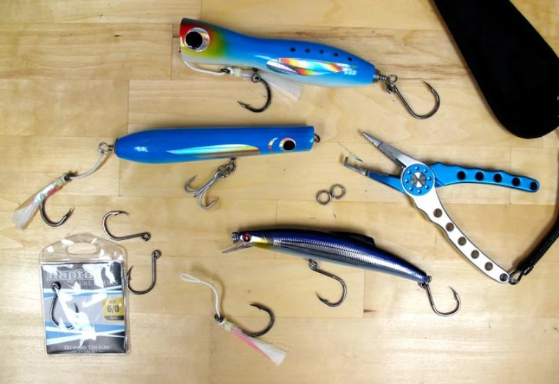 Several OTI lures and some Raptor Hooks on a table